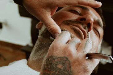 Barbero realizando afeitado