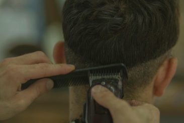 Manos de peluquero realizando corte de cabello